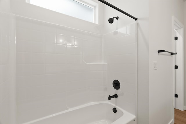 bathroom with wood finished floors and  shower combination