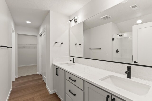 bathroom featuring a sink, visible vents, and a walk in shower