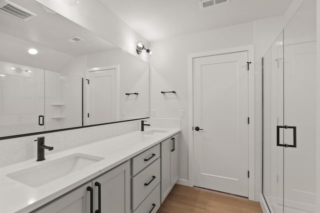 full bathroom featuring visible vents, a stall shower, and a sink
