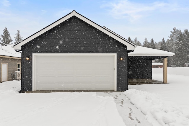 snow covered garage featuring a detached garage
