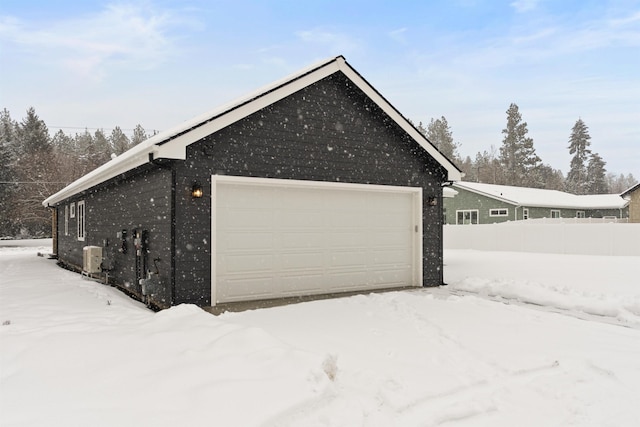 snow covered garage with a detached garage