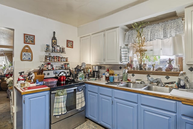 kitchen featuring blue cabinets, a sink, light countertops, stainless steel electric range oven, and tasteful backsplash