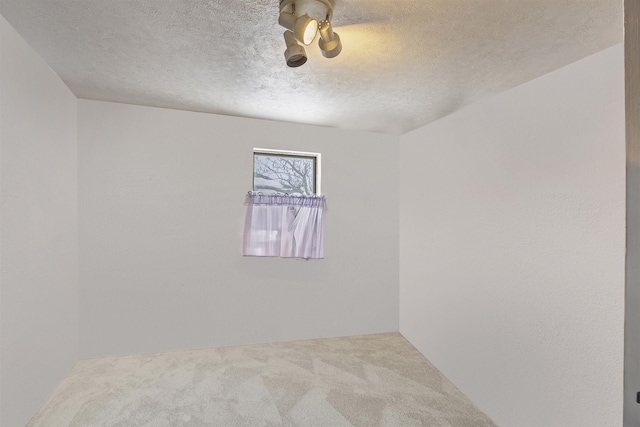 carpeted spare room featuring a textured ceiling