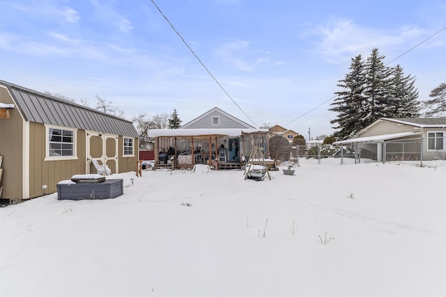 snow covered property with fence and an outbuilding