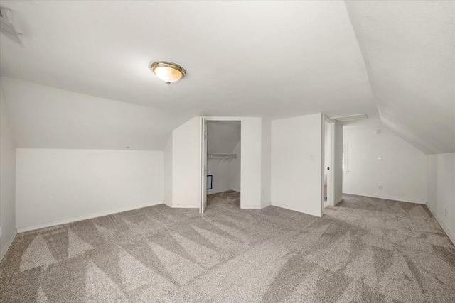 bonus room featuring lofted ceiling, light carpet, and baseboards