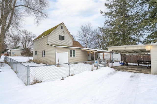 snow covered rear of property with fence