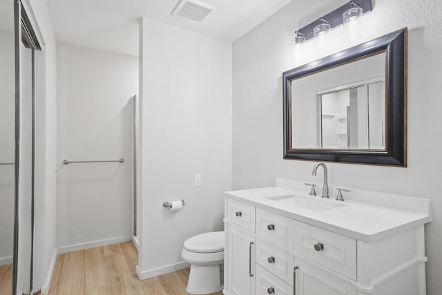 full bath with toilet, wood finished floors, vanity, visible vents, and baseboards