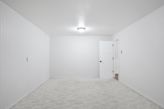 empty room featuring carpet and baseboards