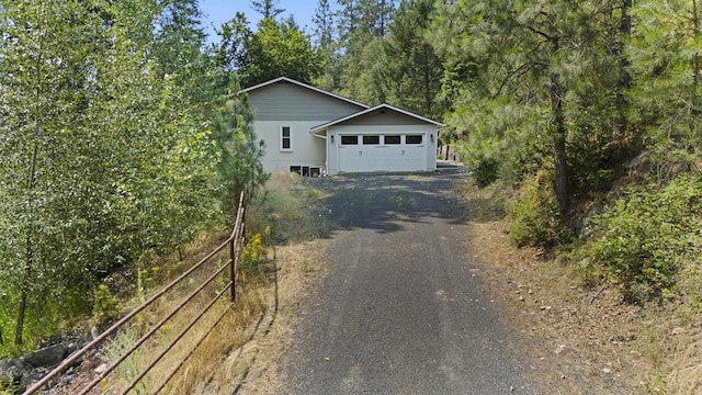 view of front of home with driveway, a garage, and fence