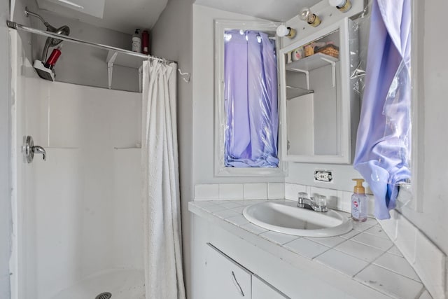 full bath with a shower stall and vanity