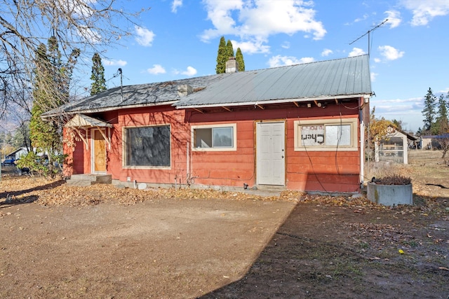 exterior space featuring a chimney and metal roof