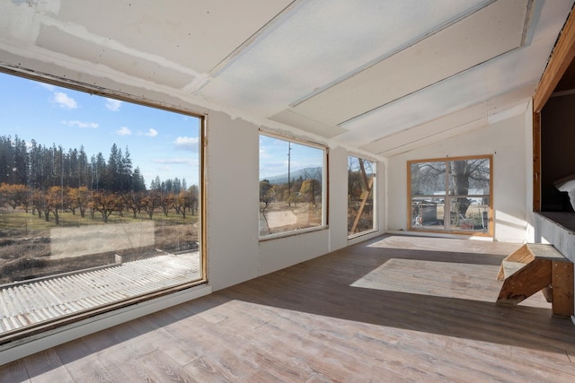 unfurnished sunroom featuring vaulted ceiling and plenty of natural light