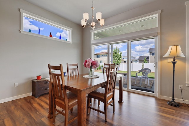 dining room featuring dark wood-style floors, baseboards, and a chandelier