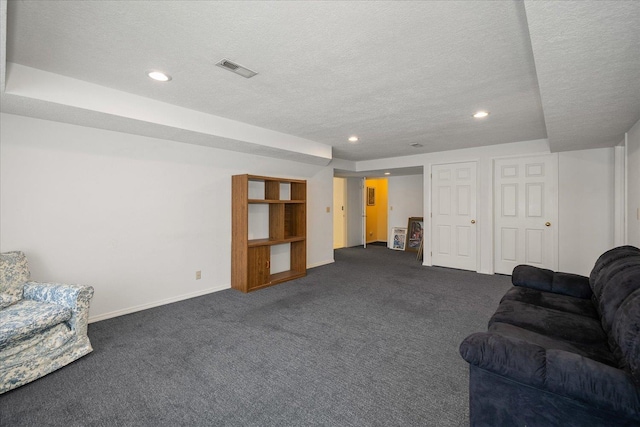 living room featuring a textured ceiling, recessed lighting, dark carpet, and baseboards