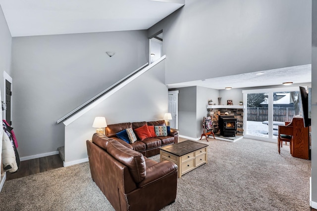 living area featuring high vaulted ceiling, dark colored carpet, and baseboards