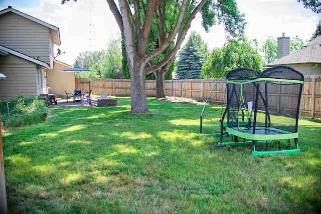 view of yard featuring a patio area, a fenced backyard, and a trampoline