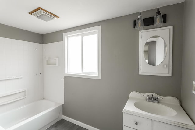 full bath featuring shower / washtub combination, vanity, baseboards, and wood finished floors