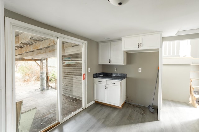 kitchen featuring dark countertops, white cabinetry, and wood finished floors