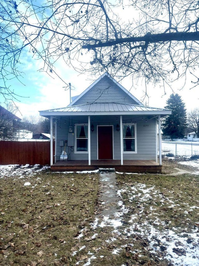 bungalow-style home featuring a porch and fence