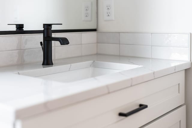 bathroom featuring a sink and decorative backsplash