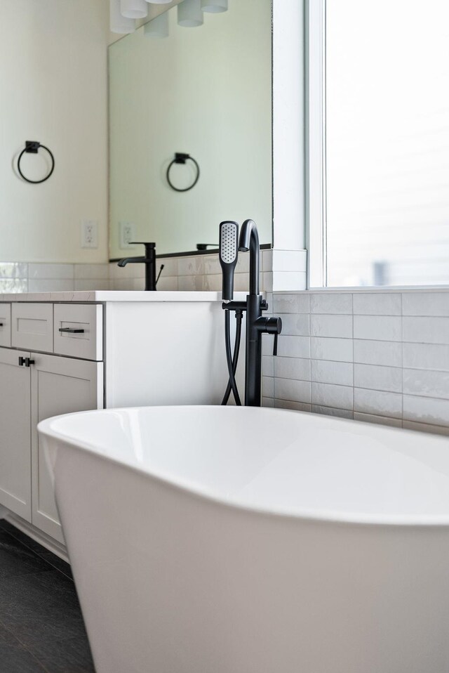 full bathroom featuring a freestanding tub and vanity