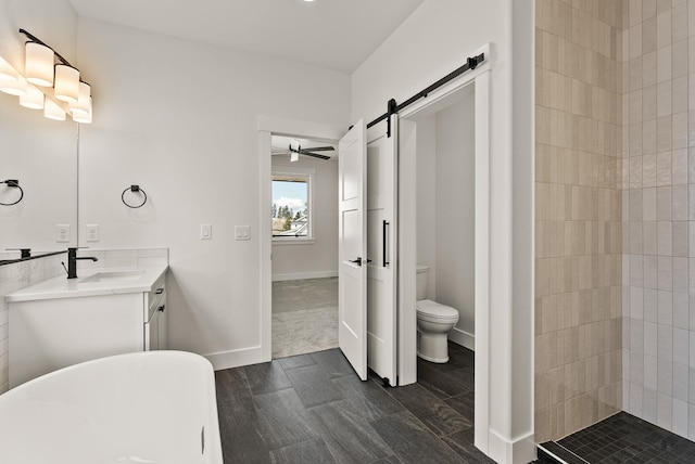 full bathroom with toilet, a freestanding tub, baseboards, and vanity