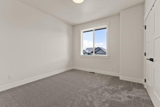 unfurnished bedroom featuring carpet, visible vents, vaulted ceiling, and baseboards