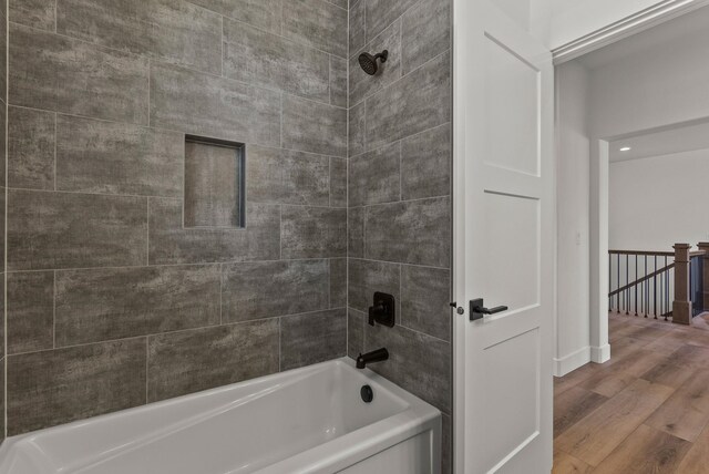 bathroom featuring wood finished floors and bathtub / shower combination