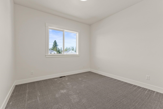 carpeted empty room with visible vents and baseboards