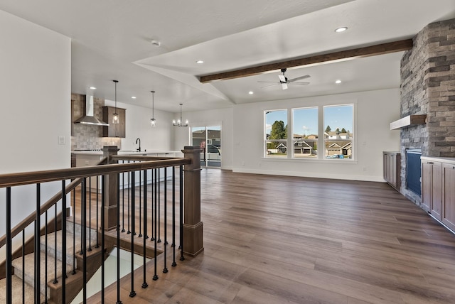 interior space featuring wall chimney range hood, dark wood-type flooring, decorative light fixtures, and decorative backsplash