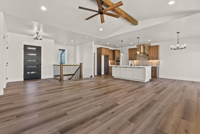 unfurnished living room featuring recessed lighting, dark wood-style flooring, lofted ceiling with beams, and ceiling fan with notable chandelier