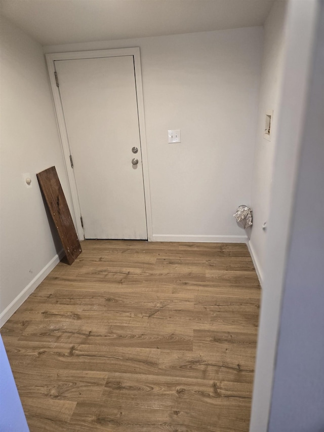 interior space featuring light wood-style flooring and baseboards