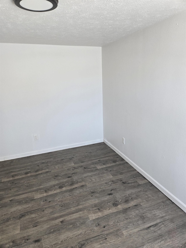 unfurnished room featuring baseboards, dark wood finished floors, and a textured ceiling