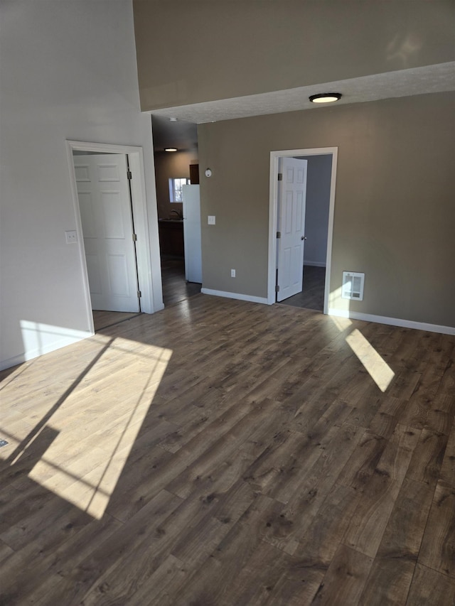 unfurnished room with dark wood-style floors and baseboards