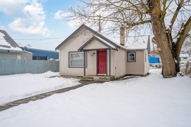 bungalow-style home with fence