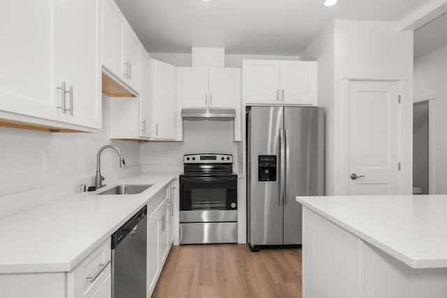 kitchen with stainless steel appliances, light countertops, white cabinetry, and under cabinet range hood