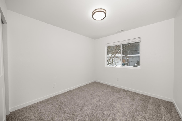 unfurnished room with carpet flooring, visible vents, and baseboards