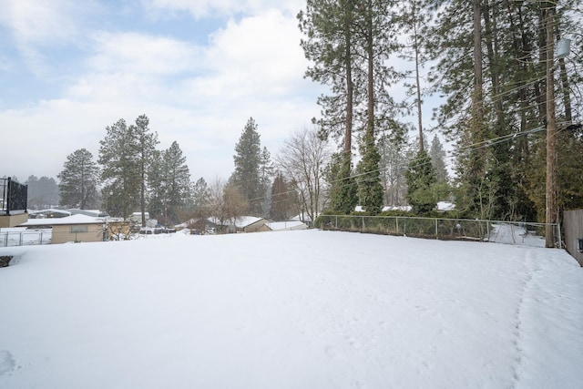 yard covered in snow featuring fence