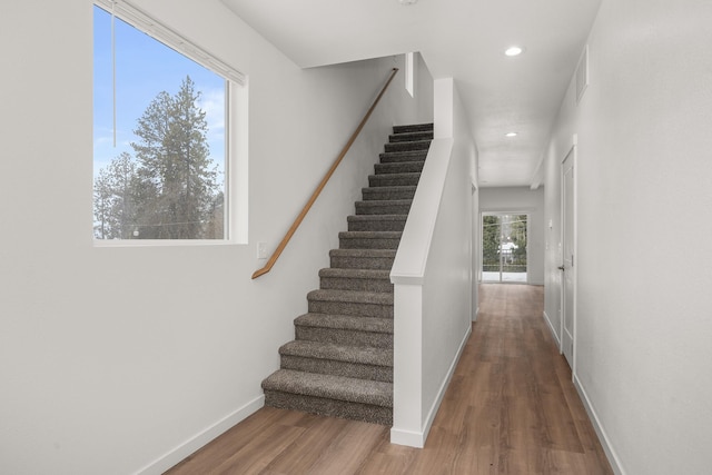 stairway featuring recessed lighting, baseboards, and wood finished floors