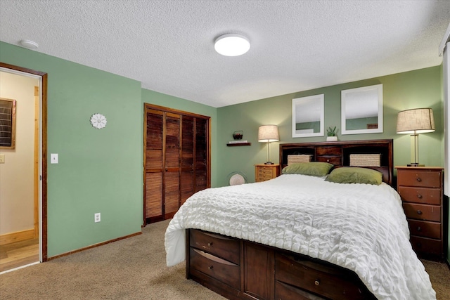 bedroom with a textured ceiling, baseboards, a closet, and light colored carpet