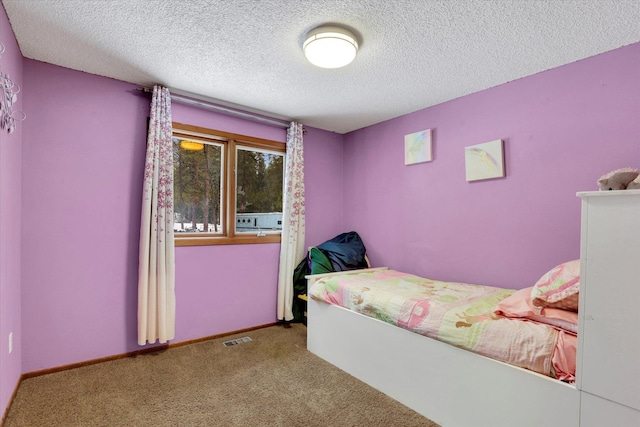 bedroom featuring carpet floors, baseboards, visible vents, and a textured ceiling