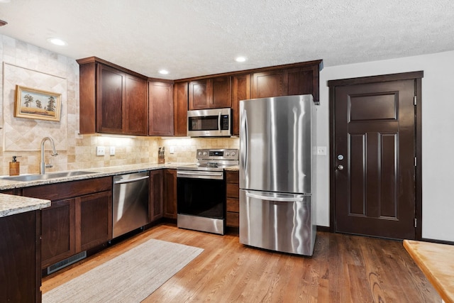 kitchen with light wood finished floors, visible vents, a sink, and appliances with stainless steel finishes
