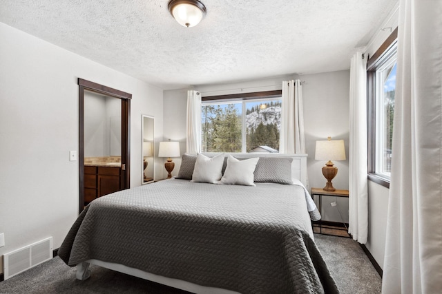 carpeted bedroom featuring visible vents, baseboards, and a textured ceiling