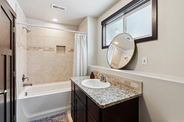 bathroom with vanity, shower / bath combo with shower curtain, and visible vents