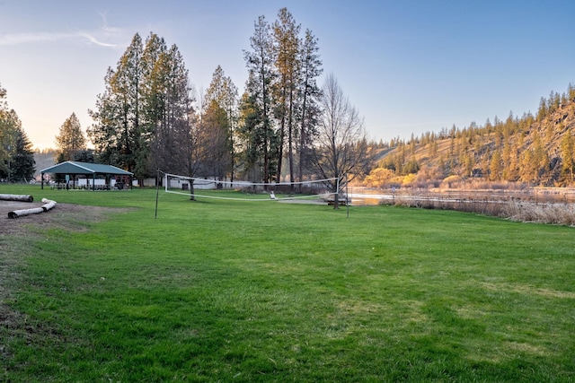 view of property's community featuring volleyball court and a lawn