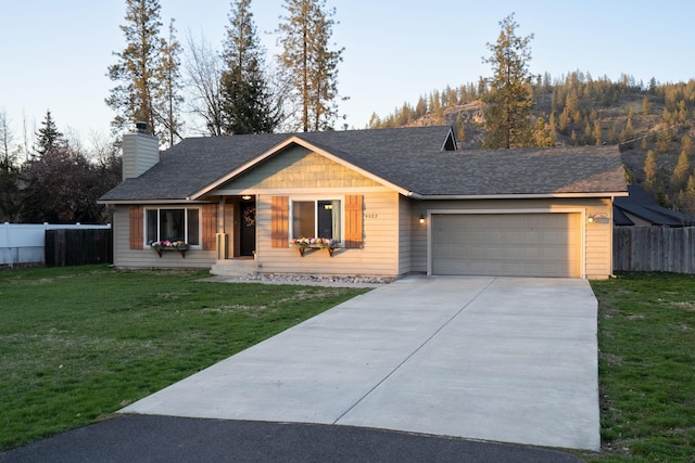 single story home with concrete driveway, a front yard, fence, and a garage