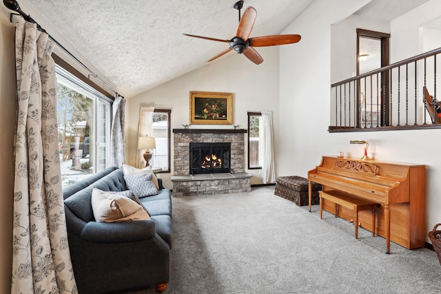 carpeted living area with lofted ceiling, a stone fireplace, a textured ceiling, and ceiling fan