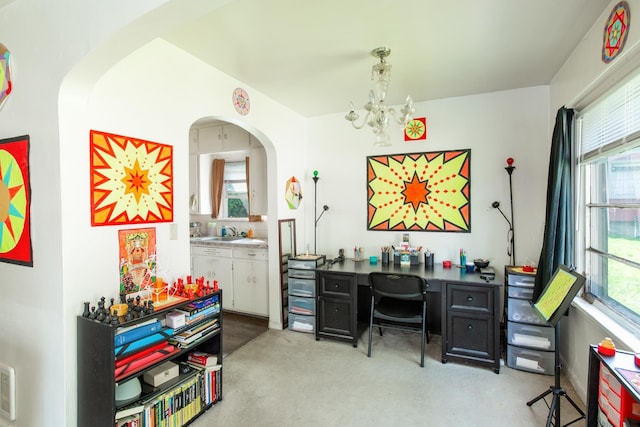 office with a chandelier, arched walkways, plenty of natural light, and a sink