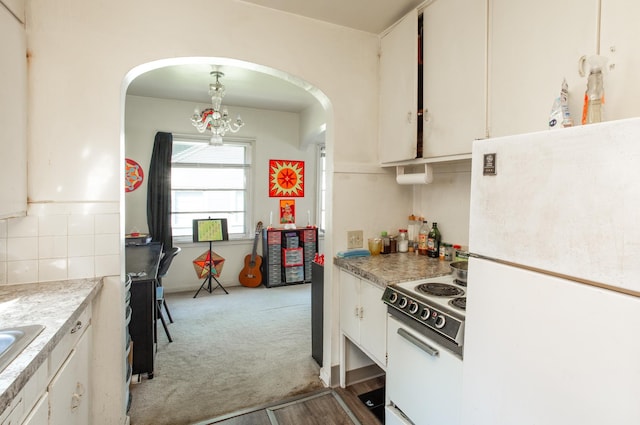 kitchen with light colored carpet, white appliances, white cabinets, light countertops, and backsplash