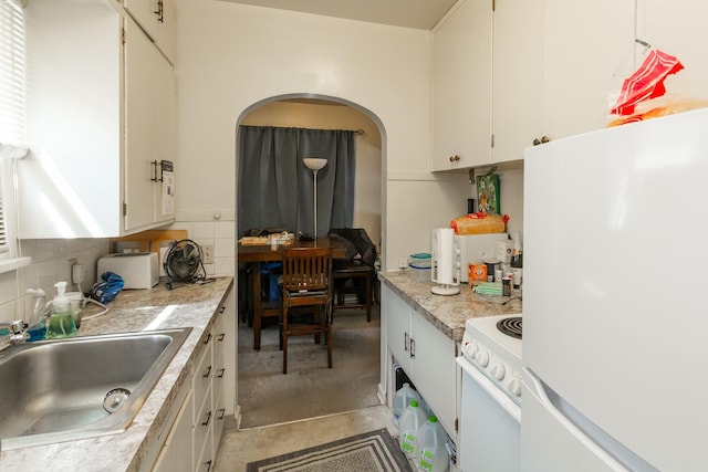 kitchen featuring light countertops, white appliances, a sink, and white cabinetry